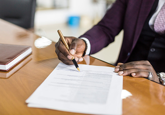 A man signing a document A man signing a document